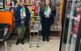 Uśmiechnięte harcerki czekają w sklepie na darczyńc&oacute;w, kt&oacute;rzy będą zapełnili kosze żywnością