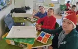Uczniowie pracują przed laptopem