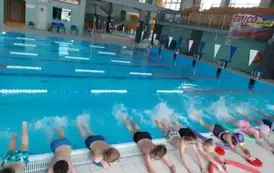 Dzieci ćwiczą ruchy n&oacute;g w wodzie