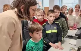 Chłopiec wprowadza dane do komputera, w tle grupa dzieci