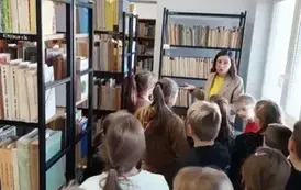 Uczniowie na tle regał&oacute;w z najstarszymi książkami