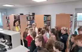 Grupa dzieci ogląda miejsce przeznaczone do wypożyczania książek