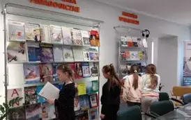 Cztery dziewczynki przeglądają czasopisma na p&oacute;lkach