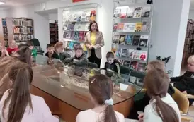 Dzieci w czytelni słuchają opowiadania Pani bibliotekarki