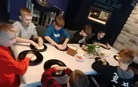 Uczniowie formują ciasto na pizzę