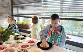 Uczeń formuje ciasto na pizzę