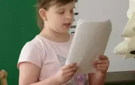 Uczennica klasy trzeciej wita gości z przedszkola