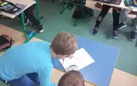 Uczniowie czytający tekst wezwania przy pomocy lupy