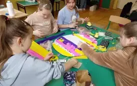 Cztery dziewczynki przyklejają kolorową bibułę