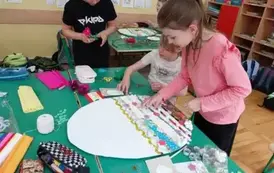 Dziewczynki wyklejają wzory na pisance