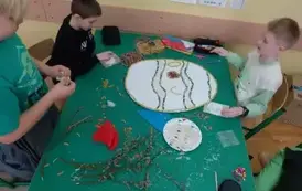 Trzech chłopc&oacute;w pracuje przy stoliku