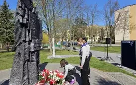 Harcerze składają kwiaty pod pomnikiem