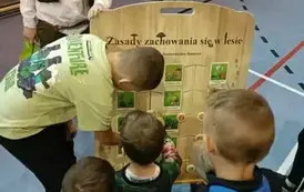Uczniowie przy planszy edukacyjnej Nadleśnictwa
