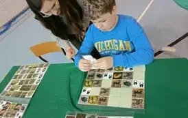 Uczniowie przy stoliku edukacyjnym Nadleśnictwa