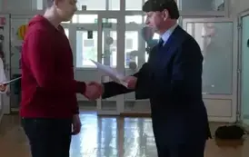 Konrad Przetak odbiera gratulacje z rąk dyrektora