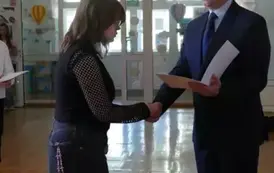 Zofia Krakowiak odbiera gratulacje z rąk dyrektora