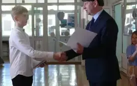 Szymon Myśliwiec odbiera gratulacje z rąk dyrektora