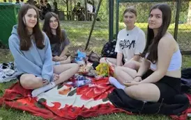 Uczennice siedzące na kocu piknikowym