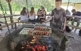 Uczeń przy smażeniu kiełbasek