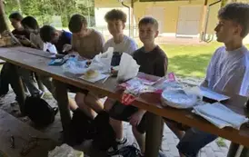 Grupa uczni&oacute;w przy stole piknikowym