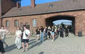 &Oacute;smoklasiści wraz z opiekunami wchodzący na teren obozu Birkenau