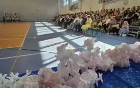 Dekoracja stołu z nagrodami i widownia., w tle poczet sztandarowy i flagowy