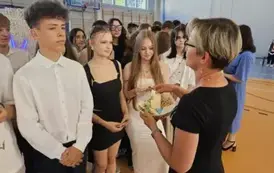 Wychowawczyni 8C rozdaje uczniom koniczynki wydrukowane na drukarce 3D