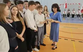 Wychowawczyni 8D rozdaje uczniom koniczynki wydrukowane na drukarce 3D