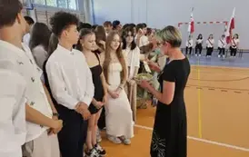 Wychowawczyni 8C rozdaje uczniom koniczynki wydrukowane na drukarce 3D