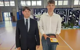 Uczeń klasy 8 B W. Fafara z nagrodą książkową i dyr. Kubalski