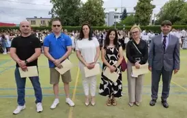 Grupa rodzic&oacute;w z dyrektorem stoją na środku