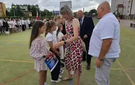 Radni i nauczyciel wręczają nagrody uczniom 