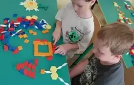 Dw&oacute;ch chłopc&oacute;w przy swoich układankach