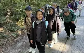 Grupa chłopc&oacute;w na leśnym szlaku