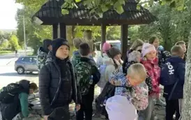 Grupa dzieci przy figurze Emeryka