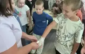 Pielęgniarka bandażuje rękę chłopcu