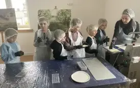 Uczniowie klasy 2 a uzupełniają foremki czekoladą