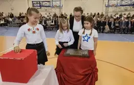 Przedstawiciele klasy III b podczas umieszczania symbolicznej tarczy na tabliczce pamiątkowej