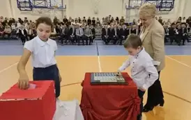 Przedstawiciele klasy II b wraz z wychowawczynią podczas umieszczania symbolicznej tarczy na tabliczce pamiątkowej