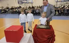 Przedstawiciele klasy II a podczas umieszczania symbolicznej tarczy na tabliczce pamiątkowej