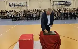 Wieloletni dyrektor szkoły Jan Gromniak podczas umieszczania symbolicznej tarczy na tabliczce pamiątkowej
