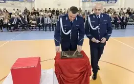 Przedstawiciele Komendy Policji w Staszowie podczas umieszczania symbolicznej tarczy na tabliczce pamiątkowej