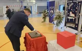 Wicewojewoda Michał Skotnicki podczas umieszczania symbolicznej tarczy na tabliczce pamiątkowej