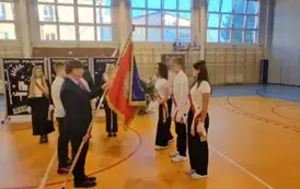 Moment przekazania nowego sztandaru przez dyrektora Kubalskiego uczniom w poczcie