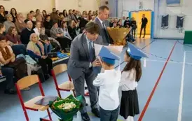 Dyrektorzy przyjmują bukiety kwiat&oacute;w od uczni&oacute;w