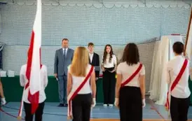 Wicedyrektor, uczniowie oraz poczet sztandarowy i flagowy podczas hymnu państwowego