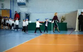 Uczniowie z nauczycielką wchodzą na uroczystość