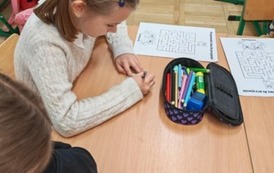 Dziewczynka z klasy trzeciej rozwiązuje działania