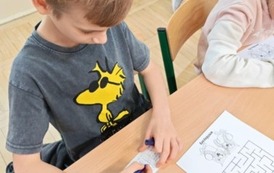 Chłopiec z klasy trzeciej rozwiązuje działania
