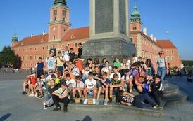 Grupowe zdjęcie uczestnik&oacute;w wycieczki pod Kolumną Zygmunta w Warszawie